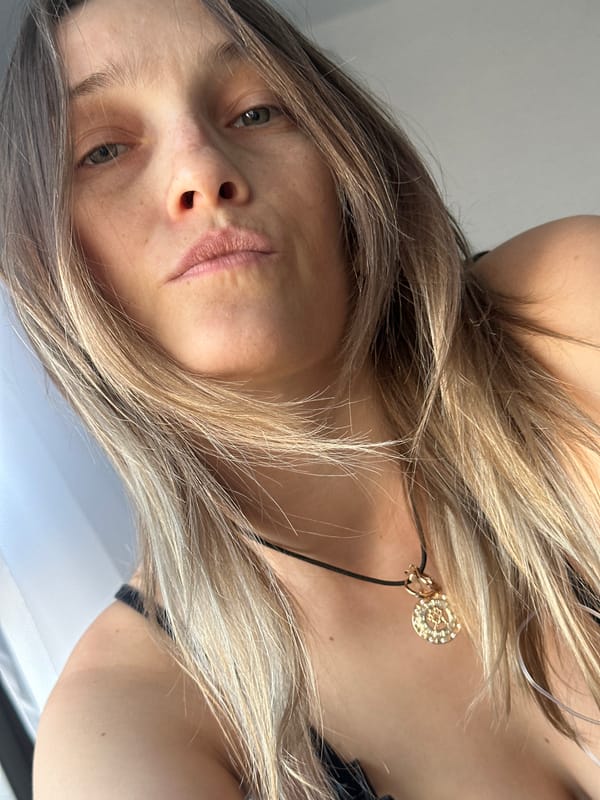 Woman photographed wearing gold pendant necklace in close-up shot