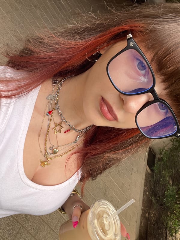 Woman takes selfies with drink in Raanana elevator, outdoors