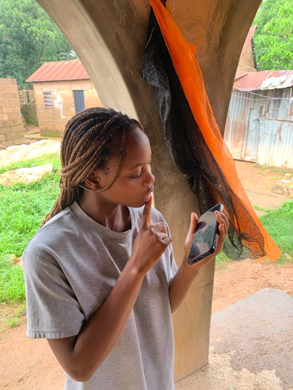Morning activity around an outdoor archway in Jos, Nigeria