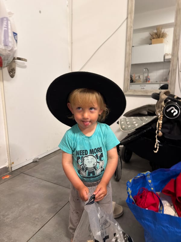 Child in oversized black hat spotted indoors in Bat Yam
