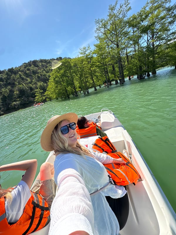 Tourists enjoy sunny boat ride on green waters near Sukko