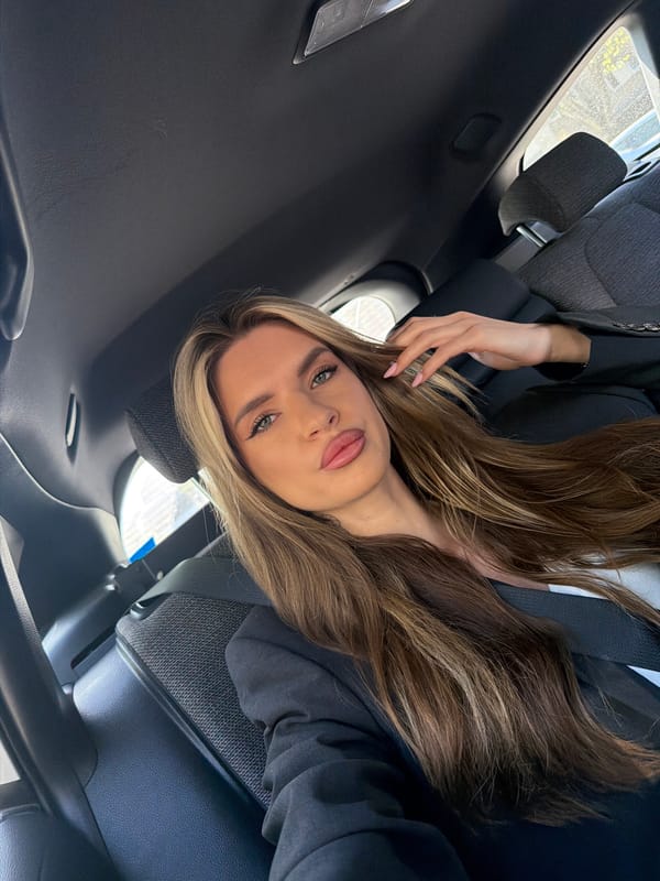 Woman photographs herself in car backseat in Berlin