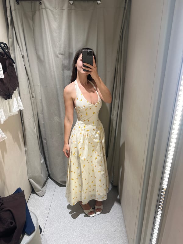 Woman tries on floral dress in changing room