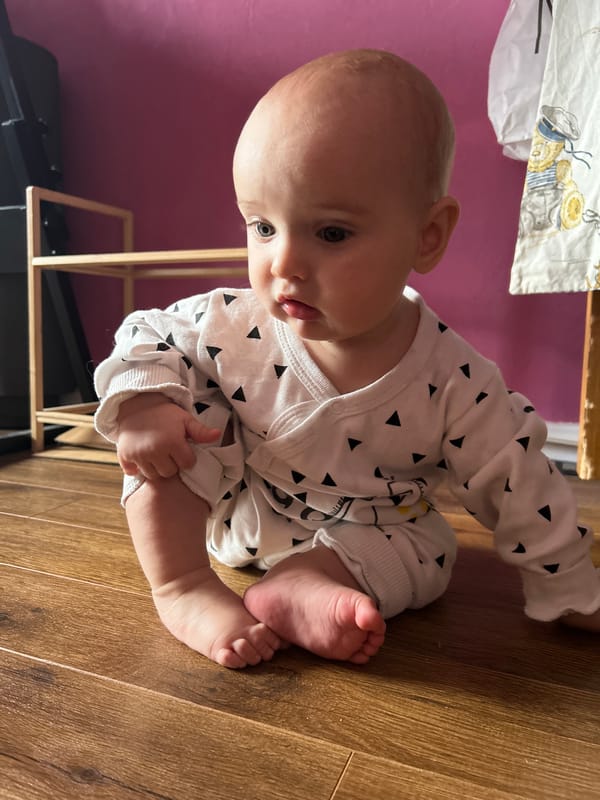 Baby plays on wooden floor in Moscow home