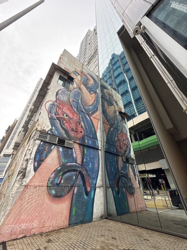 Boy cycles past dragon mural in Hong Kong morning