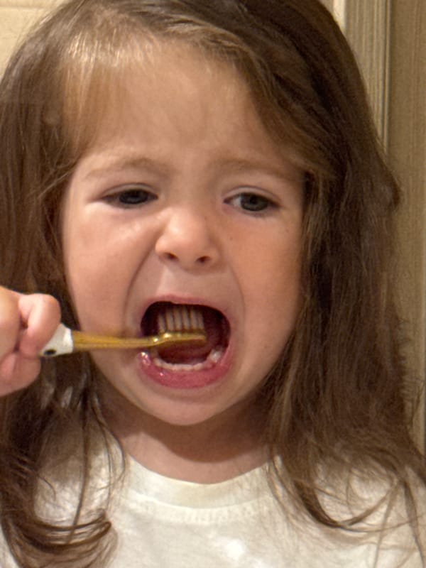 Child brushes teeth late night in Beryozovka, Russia