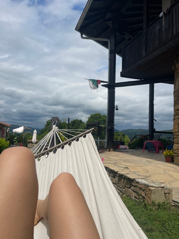 Person relaxes in hammock in Bulgarian village morning