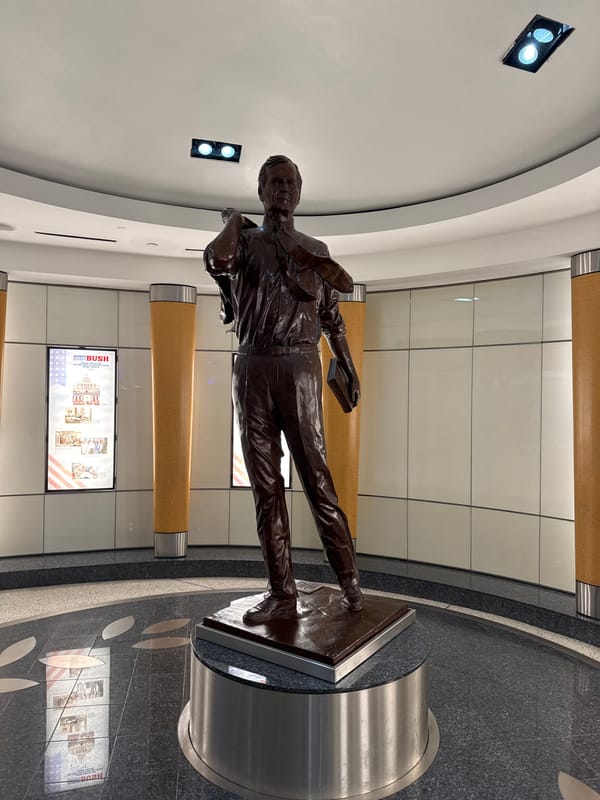 Bronze statue of suited man with book observed in Houston interior