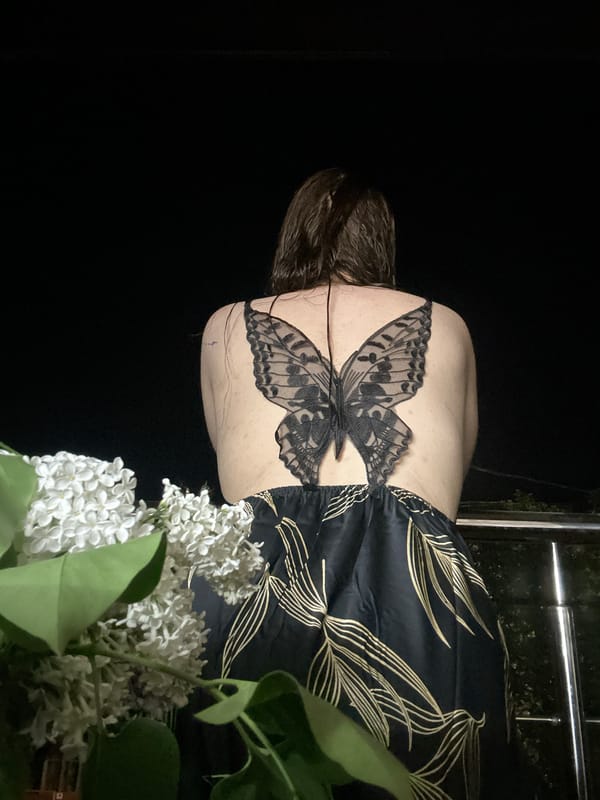 Person with butterfly tattoo observes blooming lilacs in Nizhny Novgorod
