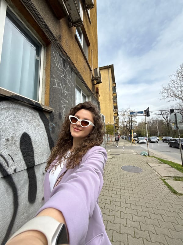 Woman takes street selfies in Sofia on overcast afternoon