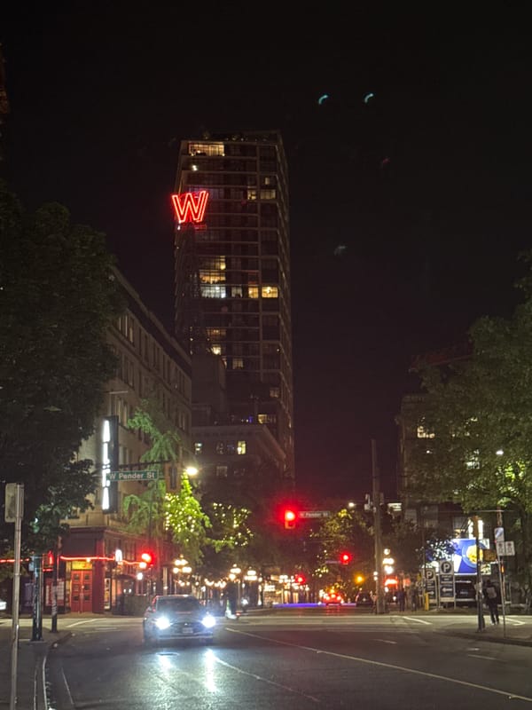 Vancouver building with illuminated W sign observed at night