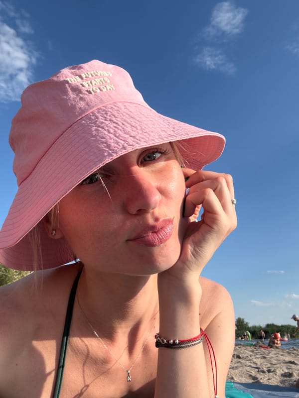 Selfie in a pink bucket hat and green bikini top
