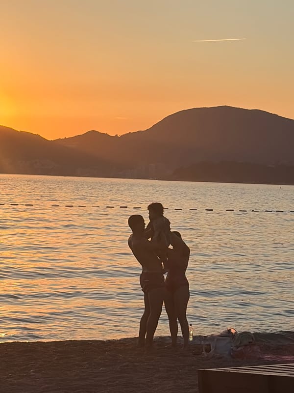 Sveti Stefan beach at golden hour, crowds and cairns