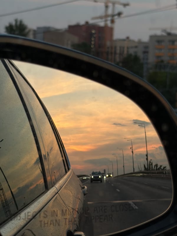 Twilight street scene captured in car mirror, Moscow