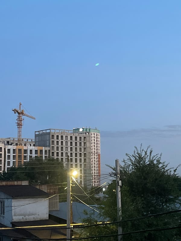 Almaty dusk: apartments, cranes, and quiet city edges