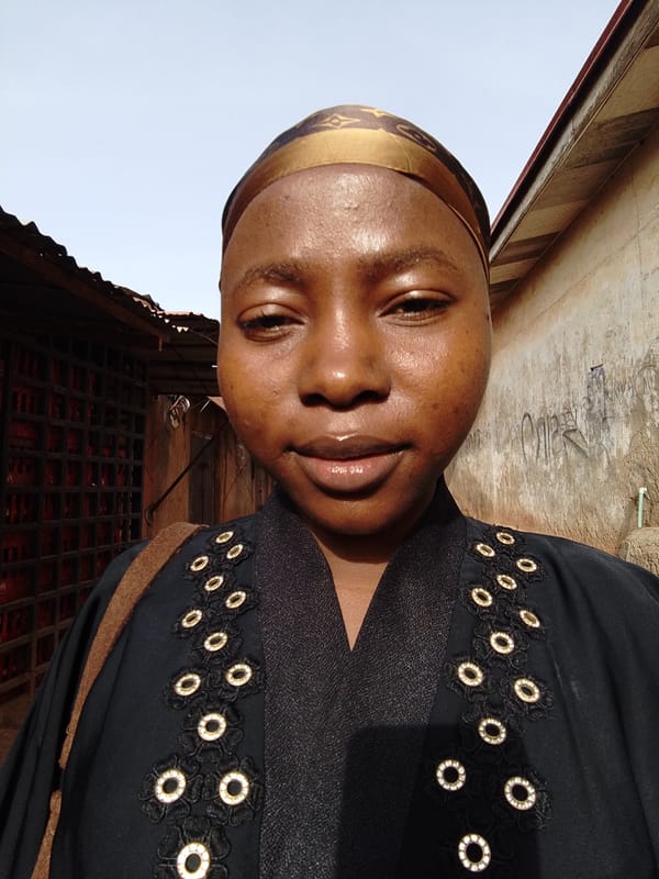Woman in decorative head covering photographed smiling at camera