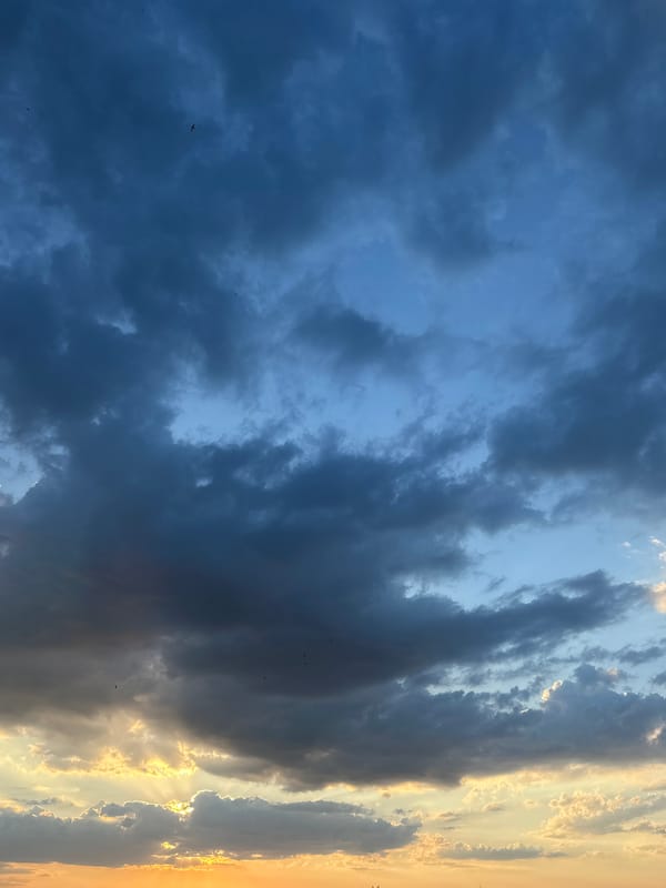 Dramatic sunset illuminates urban skyline amid storm clouds