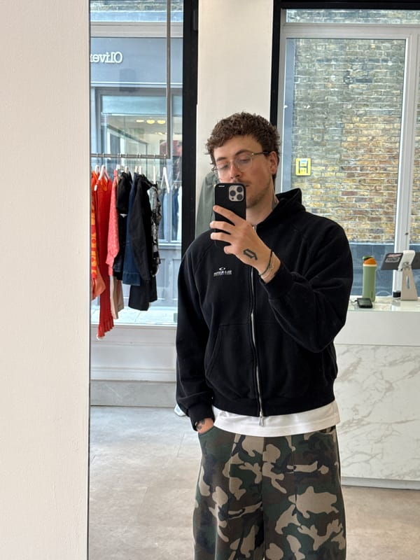 Customer takes mirror selfies at London vintage clothing store