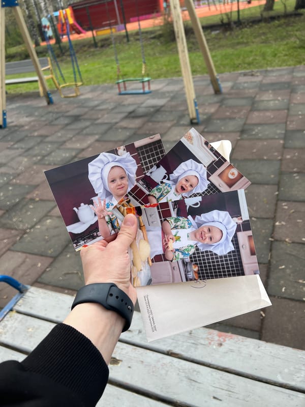Family shares printed photos during playground visit in Mytishchi