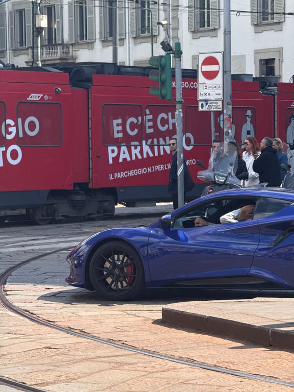 Milan street scene with parked vehicles and café accessories observed