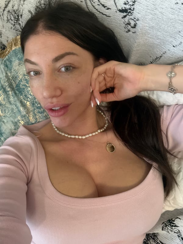 Woman in pink top and pearls rests in Sofia