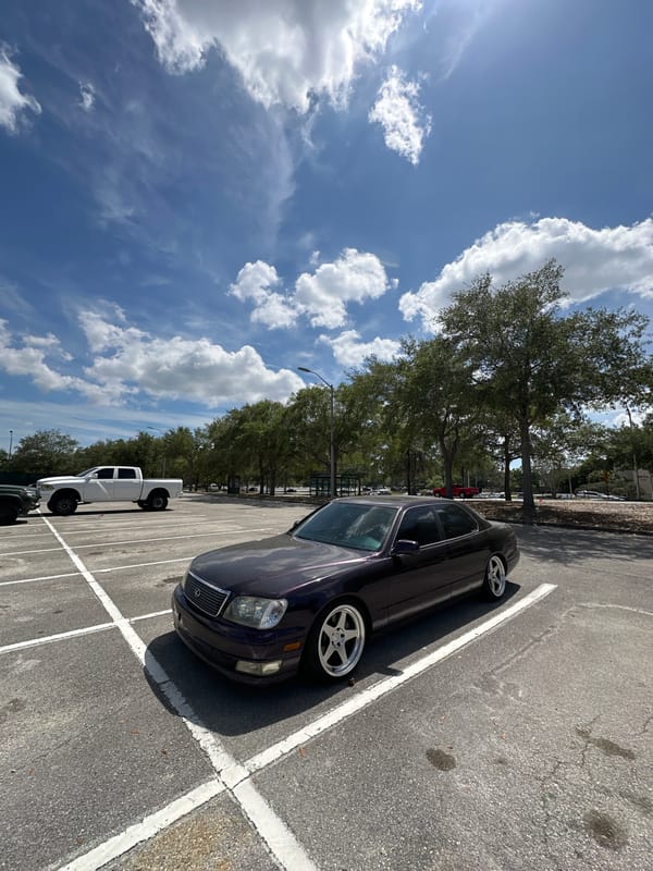 Purple sedan with custom wheels parked diagonally in Tampa lot