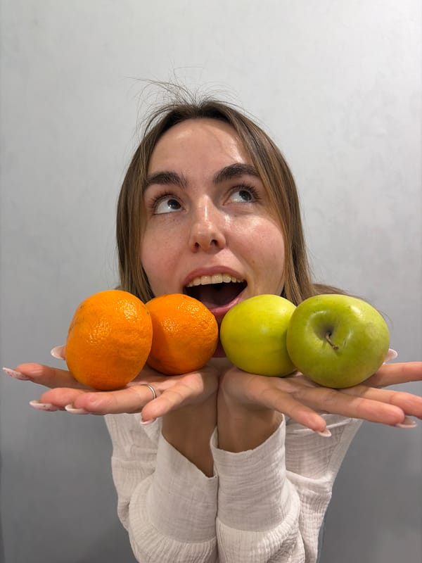 Person holds fruit to eyes in Neftekamsk kitchen
