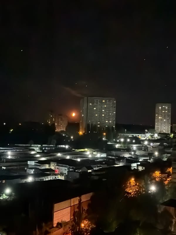Kyiv at night: city lights under an orange moon