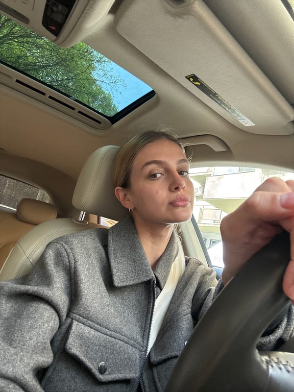 Woman sits in car driver's seat in Tbilisi