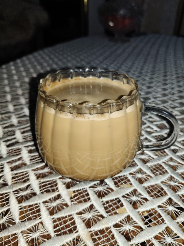 Morning coffee moment captured in glass mug on lace doily