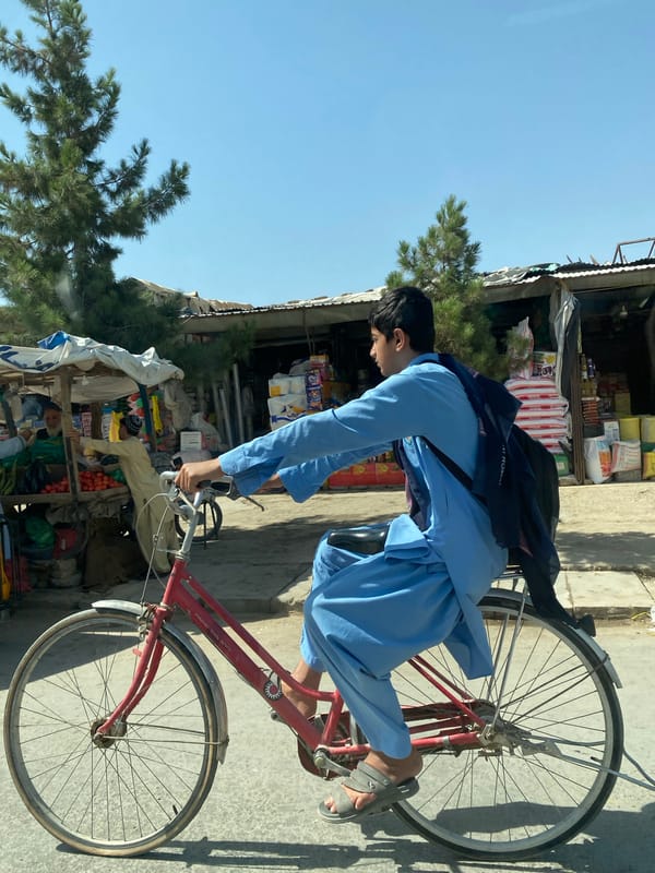 Cyclists navigate a busy Kandahar street market