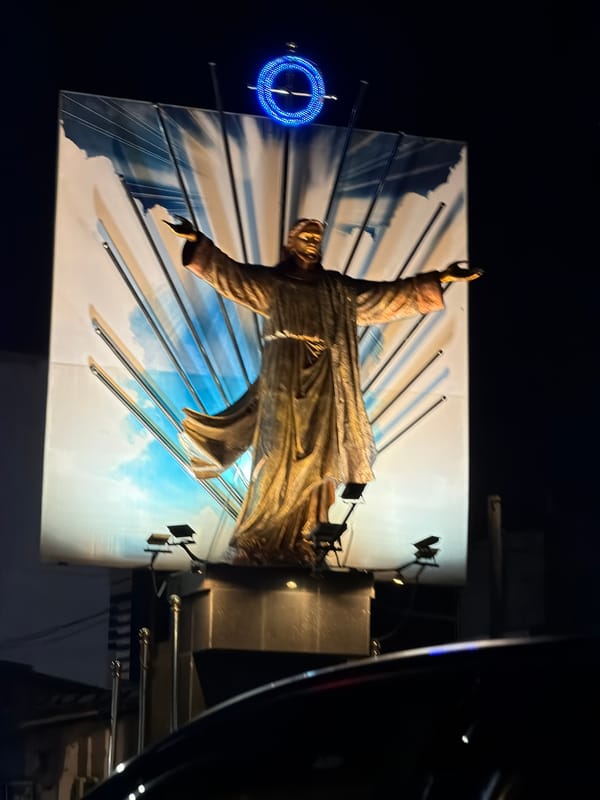 Illuminated Christ-like statue photographed at night in Ja-ela, Sri Lanka