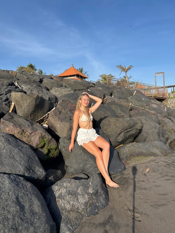 Woman poses for beach photos near temple in Mengwi