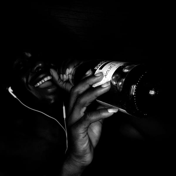 Person with headphones photographed holding drinks in Narayi, Nigeria