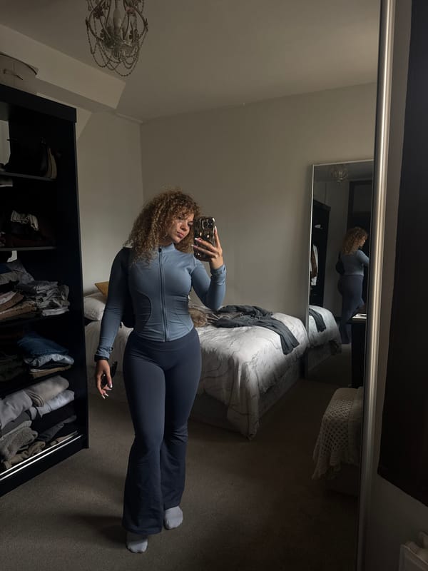 Woman takes bedroom mirror selfies in London athletic wear