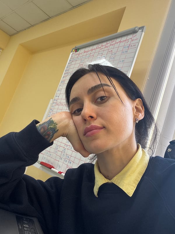 Woman in contemplative pose at desk in Tbilisi