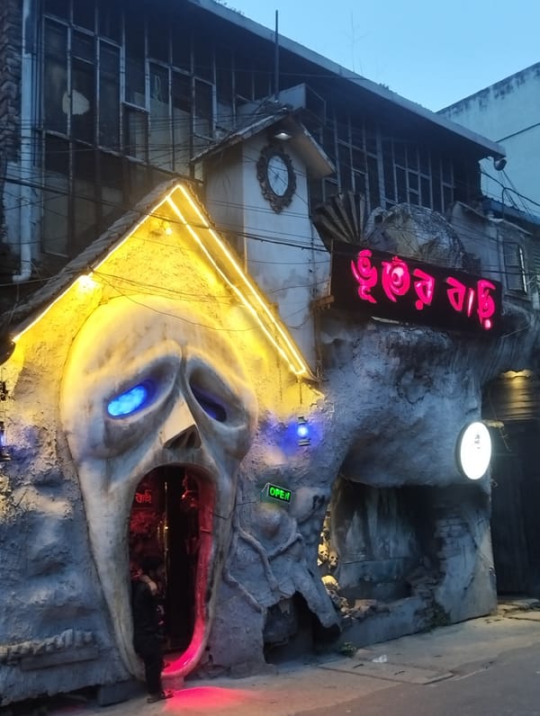 Street vendors sell flowers and food near haunted house
