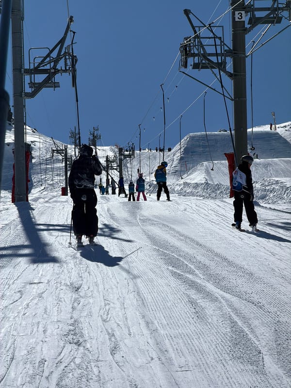 Skiers ride lift up snowy mountain in Saint-Martin-de-Belleville