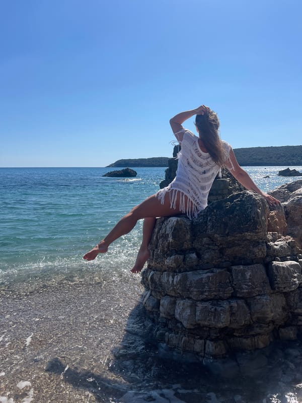 Woman poses with food on Montenegro beach