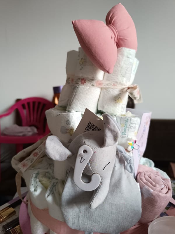 Decorated diaper cake with pink bow spotted