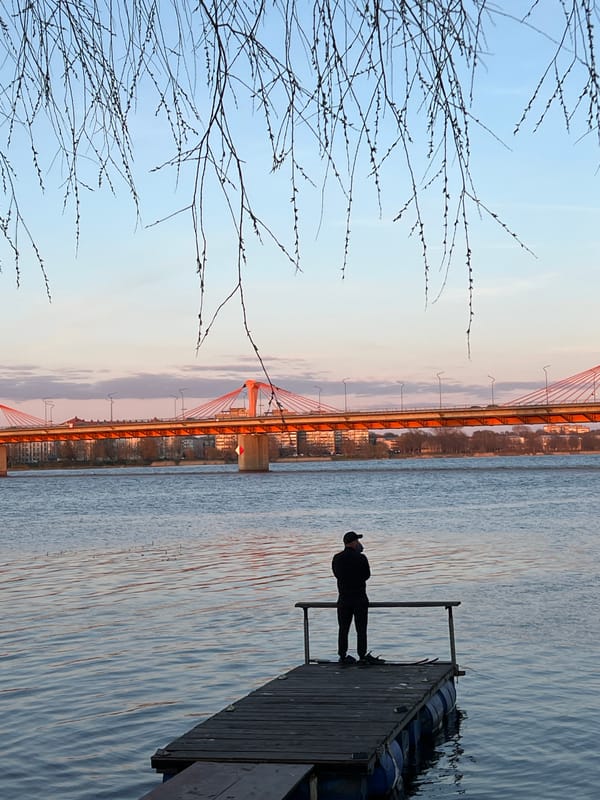 Father and child share quiet moment by Daugava River