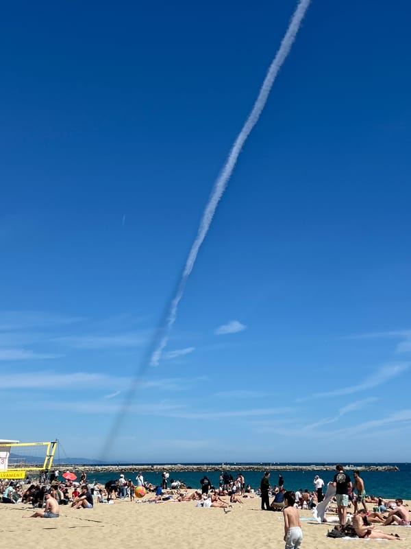 Dense crowds gather at Barcelona beach under clear skies