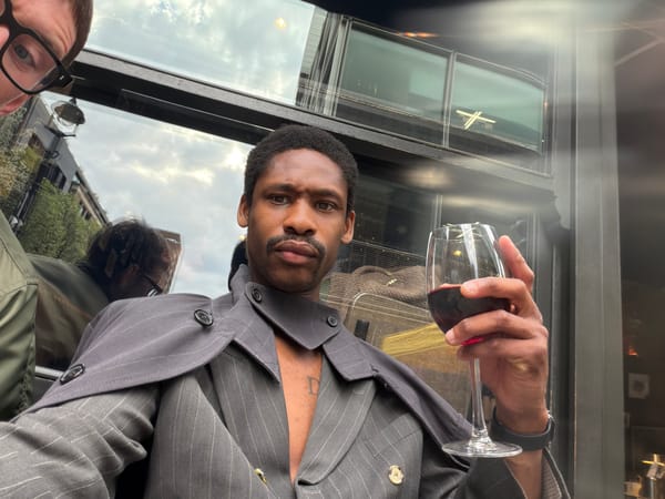 Man enjoys red wine in pinstripe suit in London