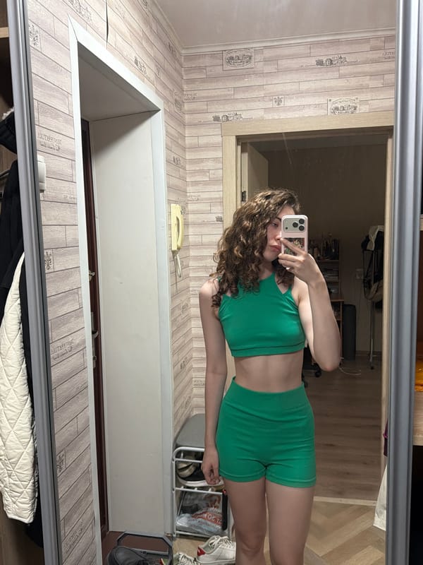 At-home selfie session in a Tyumen apartment, green athletic wear