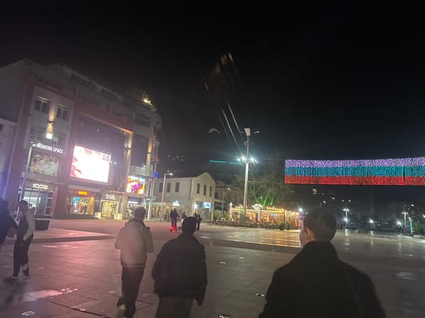 Evening pedestrians cross central square in Burgas, Bulgaria