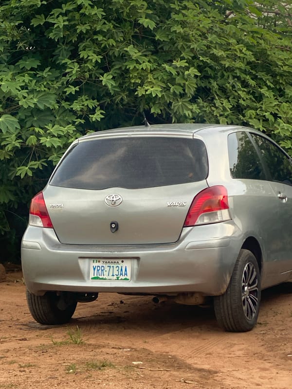 Multiple vehicles parked and attended to on Jalingo's dirt roads