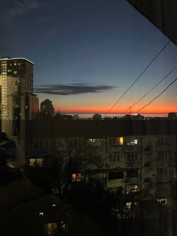 Evening sunset illuminates Sochi cityscape with orange sky