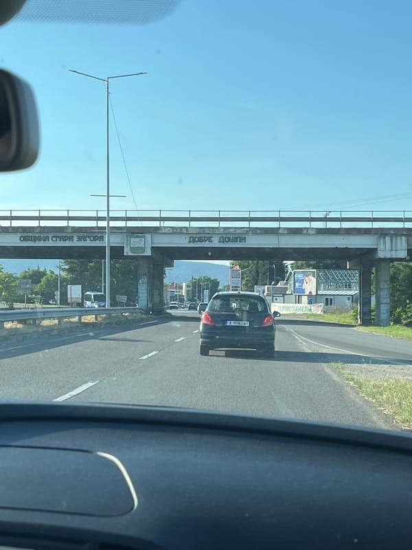 Vehicle approaches highway underpass with Cyrillic signage in Bulgaria
