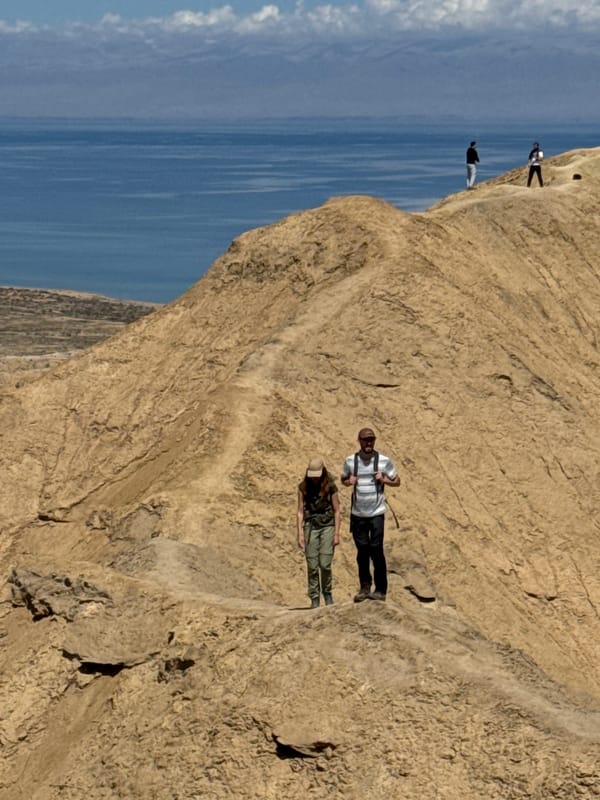 Hikers traverse rocky cliffs near Tong, Kyrgyzstan