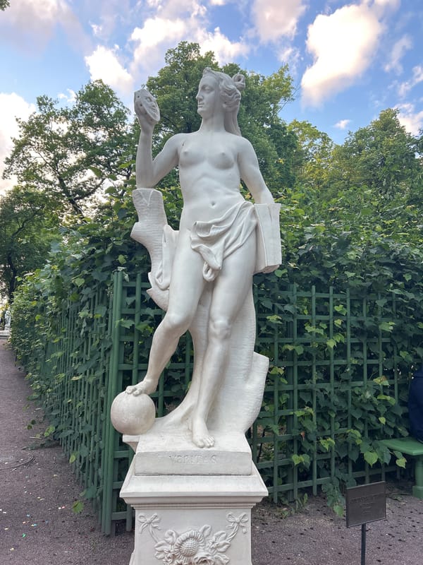 Classical statues, fountains, and ornate buildings in a historic park